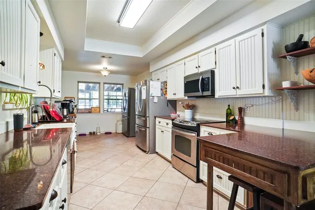 a kitchen that has a lot of cabinets and appliances in it
