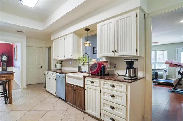 a kitchen with white cabinets and sink