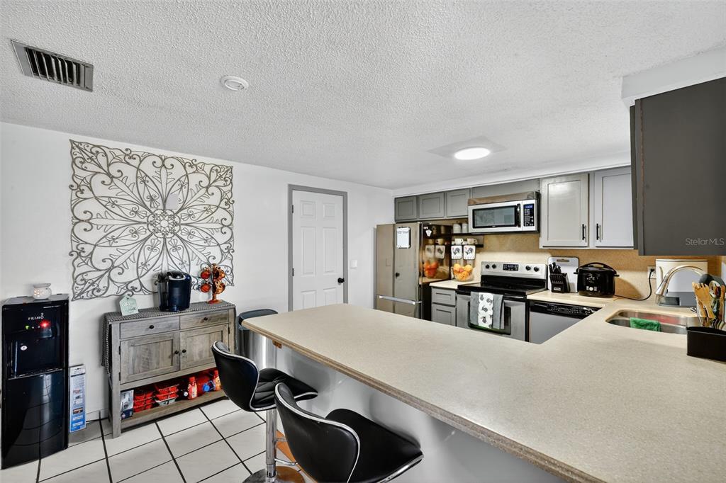 3837 Darlington Road Holiday, FL 34691 - Photo 10 of 28 a kitchen with stainless steel appliances a stove a sink a refrigerator cabinets and dining table