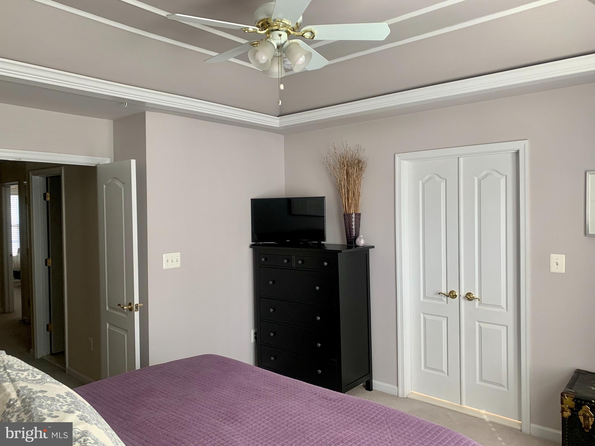 9823 Darcy Forest Drive Silver Spring, MD 20910 - Photo 17 of 32 a bedroom with a bed and a flat tv screen on dresser