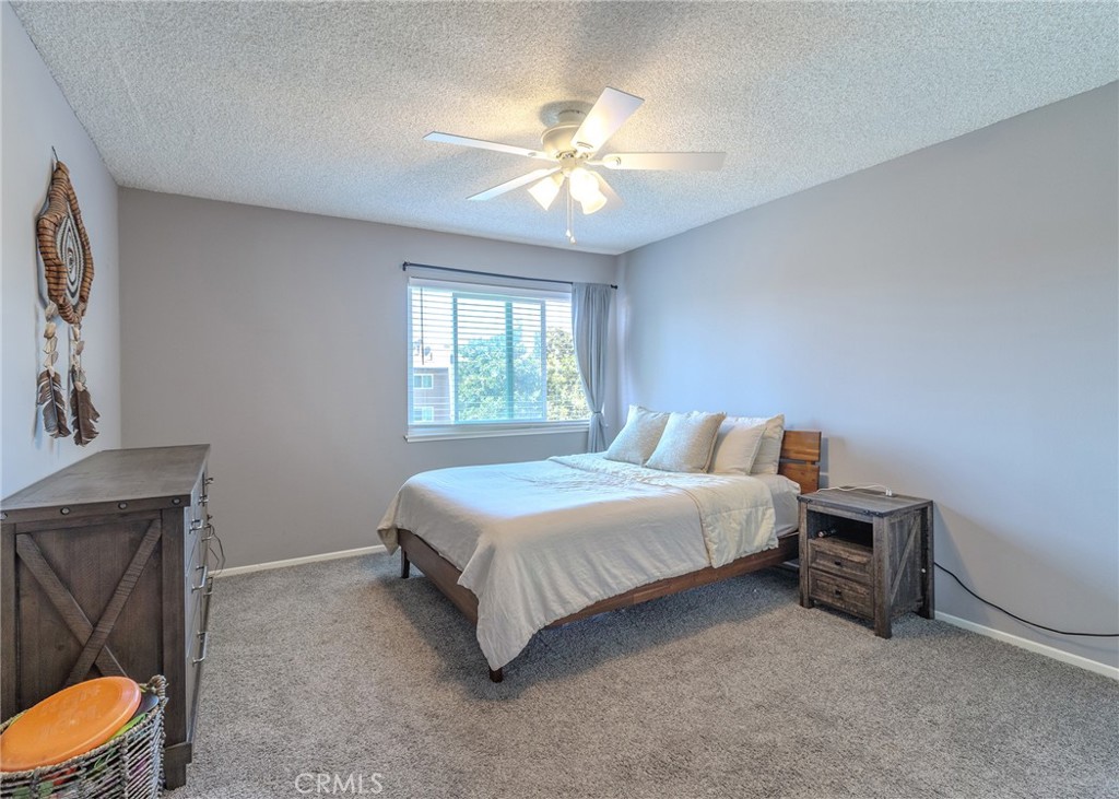 12200 Montecito Road, Unit D320 Seal Beach, CA 90740 - Photo 13 of 27 a spacious bedroom with a bed and a chandelier
