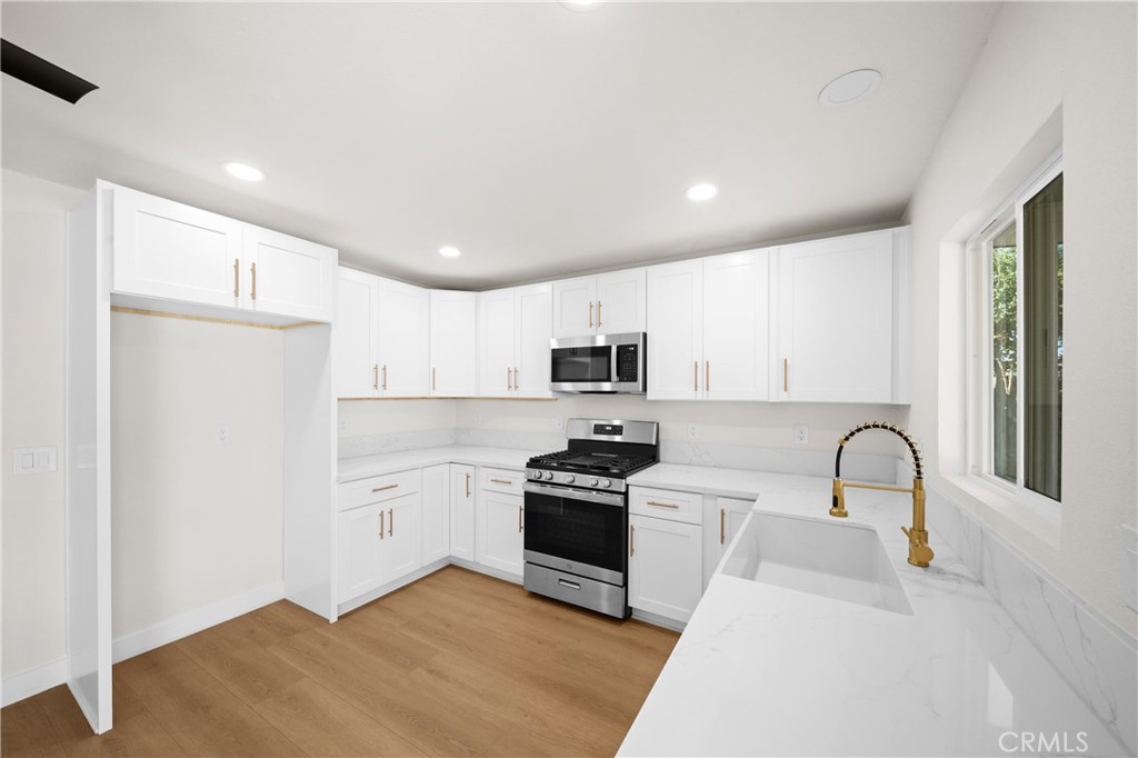 7931 Silverado Place Riverside, CA 92503 - Photo 13 of 35 a kitchen with granite countertop white cabinets and stainless steel appliances
