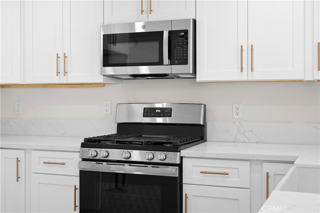 7931 Silverado Place Riverside, CA 92503 - Photo 16 of 35 a kitchen with stainless steel appliances granite countertop white cabinets a stove top oven and granite counter tops