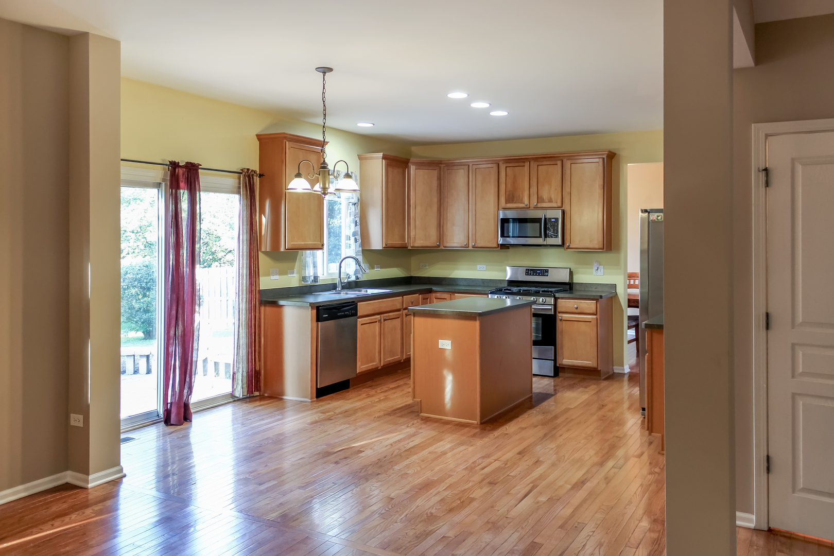 1546 Clear Drive Bolingbrook, IL 60490 - Photo 5 of 30 a kitchen with stainless steel appliances granite countertop wooden floors and white cabinets