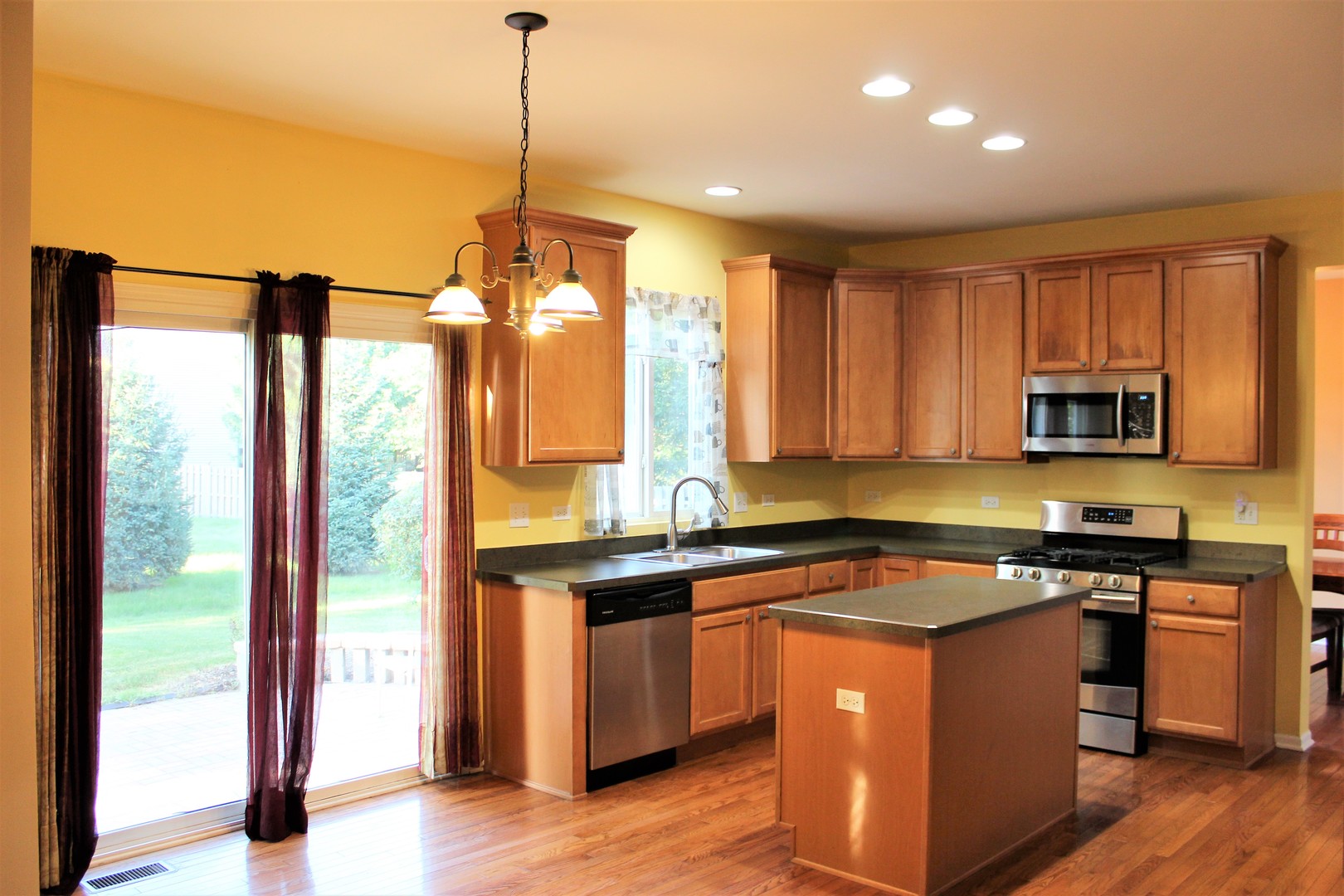1546 Clear Drive Bolingbrook, IL 60490 - Photo 6 of 30 a kitchen with stainless steel appliances granite countertop a stove a sink and a refrigerator with wooden floor