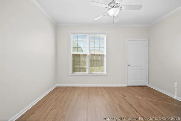 an empty room with a window and a fan