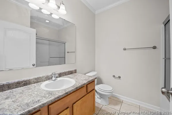 a bathroom with a granite countertop toilet a sink and a mirror