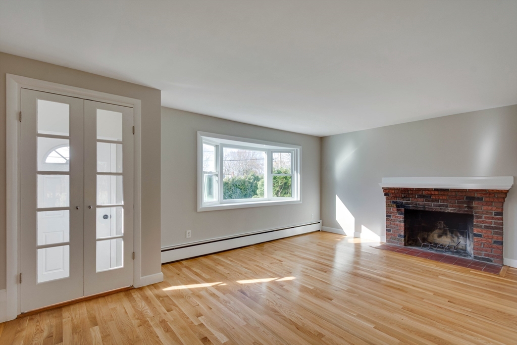 34 Irving Drive Walpole, MA 02081 - Photo 14 of 42 an empty room with wooden floor fireplace and windows