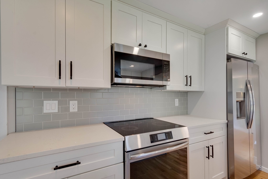 34 Irving Drive Walpole, MA 02081 - Photo 4 of 42 a kitchen with stainless steel appliances granite countertop white cabinets and a stove a oven with white countertops