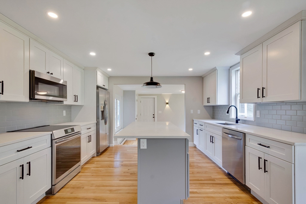 34 Irving Drive Walpole, MA 02081 - Photo 5 of 42 a large kitchen with stainless steel appliances granite countertop a sink and dishwasher a stove top oven with white cabinets
