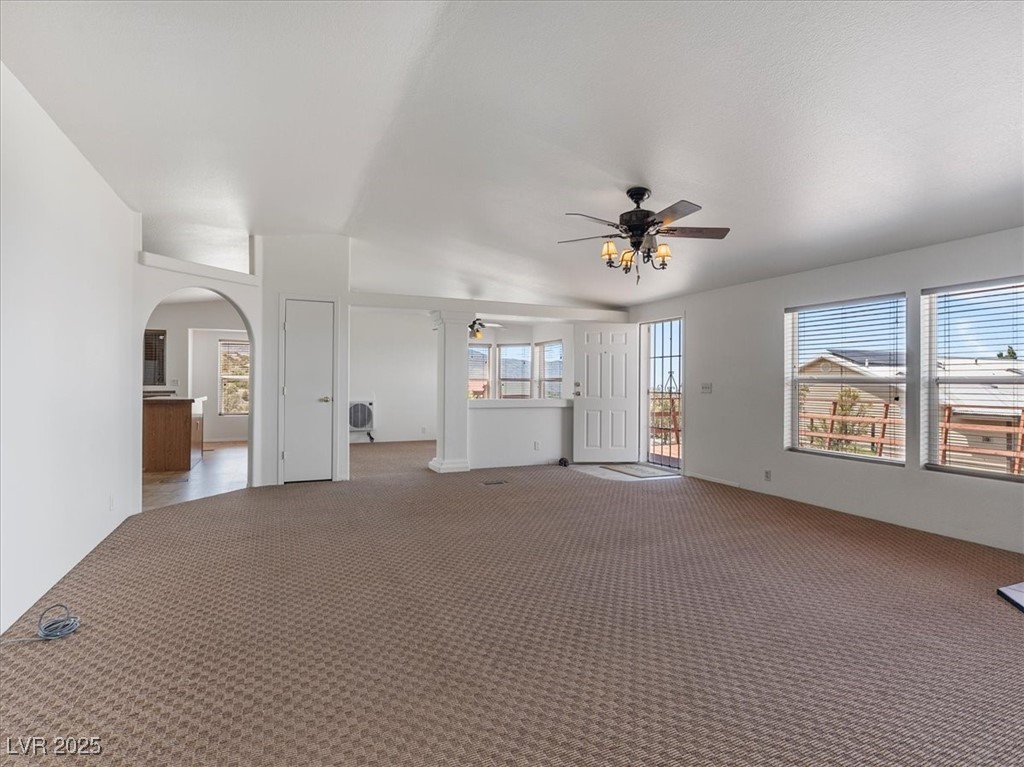 70 West Bonanza Road Las Vegas, NV 89124 - Photo 15 of 71 Unfurnished living room featuring ceiling fan, arched walkways, and carpet flooring