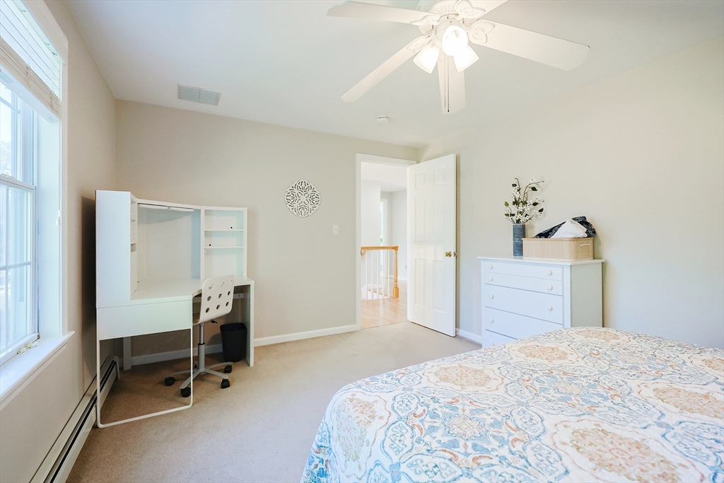 52 Quail Creek Road North Attleboro, MA 02760 - Photo 21 of 42 a bedroom with a bed and a chandelier