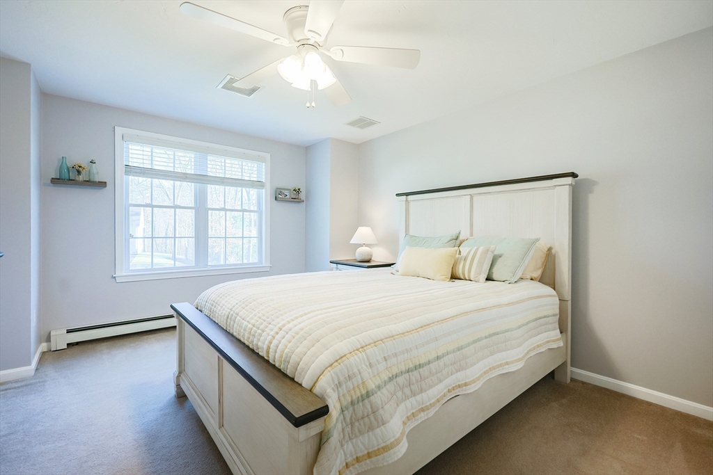 52 Quail Creek Road North Attleboro, MA 02760 - Photo 24 of 42 a bedroom with a large bed and a chandelier