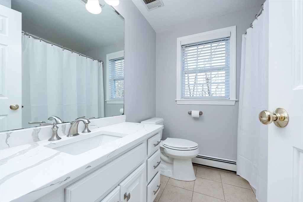 52 Quail Creek Road North Attleboro, MA 02760 - Photo 26 of 42 a bathroom with a granite countertop sink a toilet and a mirror