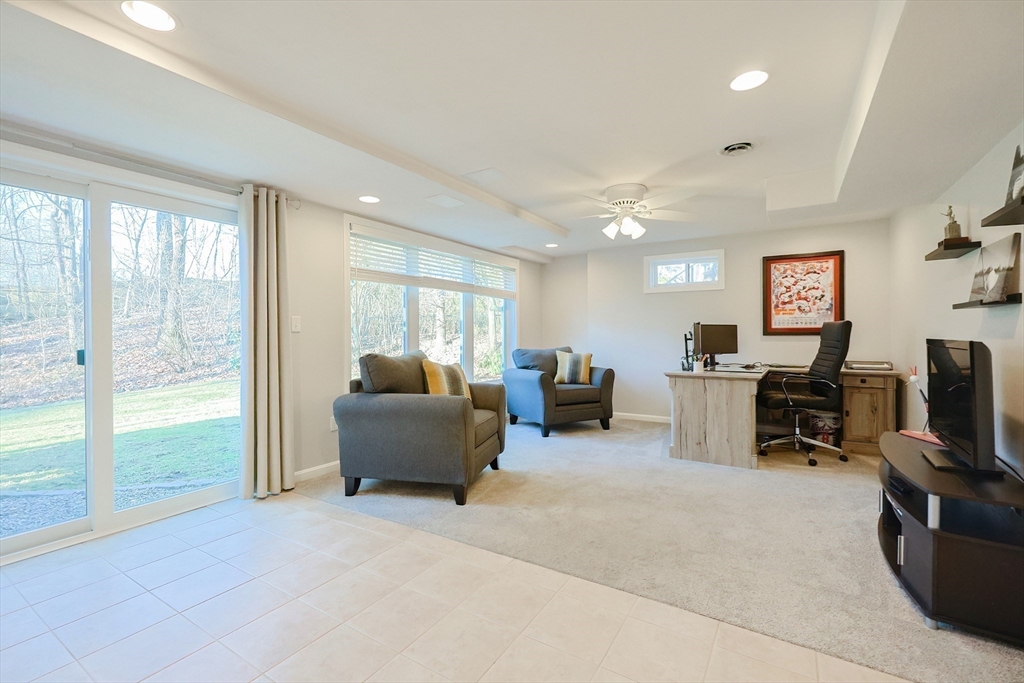 52 Quail Creek Road North Attleboro, MA 02760 - Photo 34 of 42 a living room with furniture a flat screen tv and a floor to ceiling window