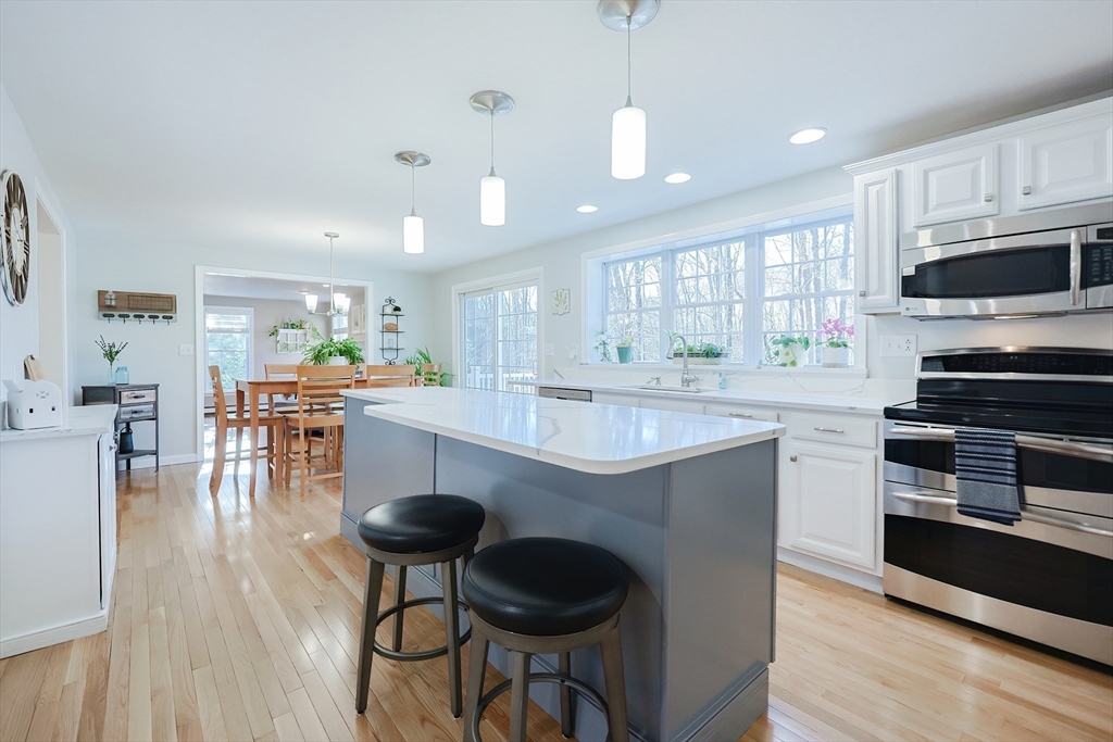 52 Quail Creek Road North Attleboro, MA 02760 - Photo 4 of 42 a kitchen with stainless steel appliances granite countertop a stove a sink a microwave a center island and furniture