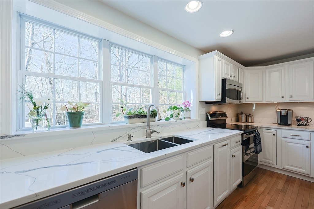 52 Quail Creek Road North Attleboro, MA 02760 - Photo 9 of 42 a kitchen with a sink a window appliances and white cabinets