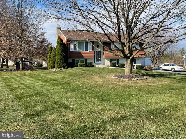 a front view of a house with a yard and trees