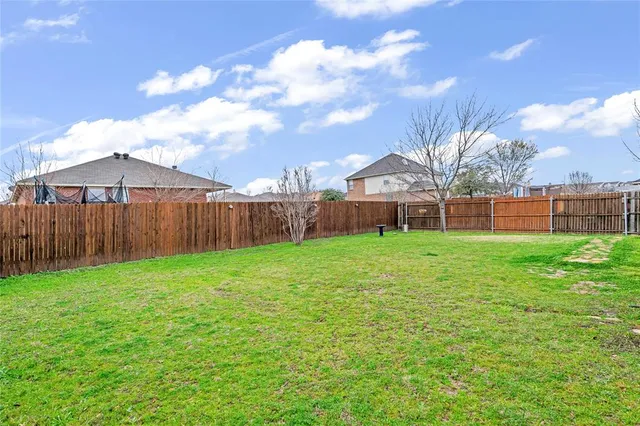 a view of a yard with an iron fence