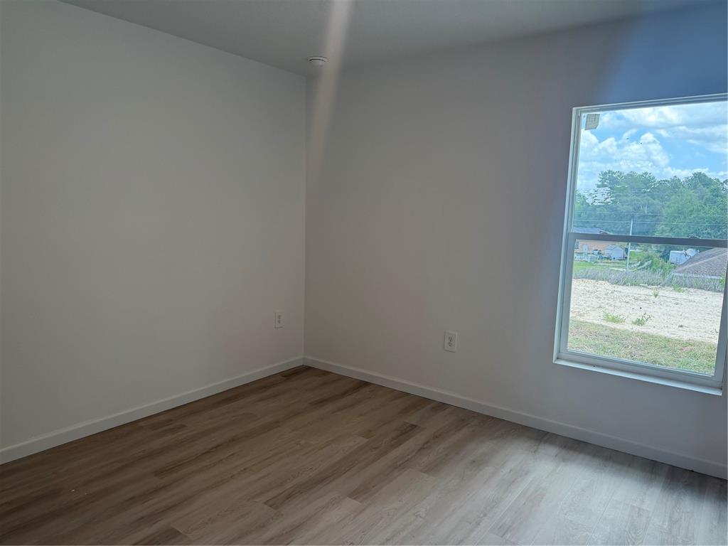 12847 Southwest 84th Terrace Road Ocala, FL 34473 - Photo 12 of 16 a view of a room that has wooden floor and large window