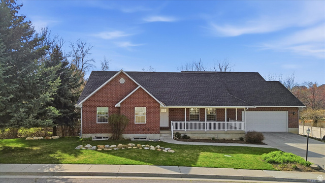 353 Robin Street Smithfield, UT 84335 - Photo 67 of 70 Ranch-style home with covered porch, a front yard, brick siding, and driveway