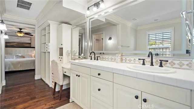 a en suite bathroom with a double vanity sink a mirror and a bathtub