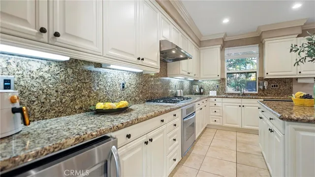 a kitchen with granite countertop a sink stainless steel appliances and cabinets