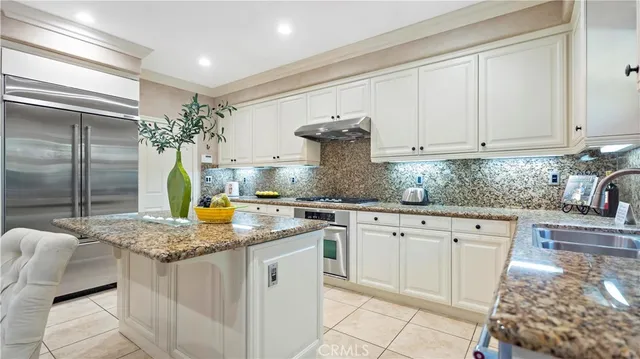 a kitchen with stainless steel appliances granite countertop a sink stove and cabinets
