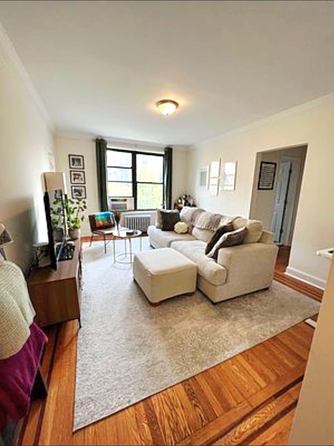 83-64 Talbot Street, Unit 4B Queens, NY 11415 - Photo 11 of 16 a living room with furniture and wooden floor