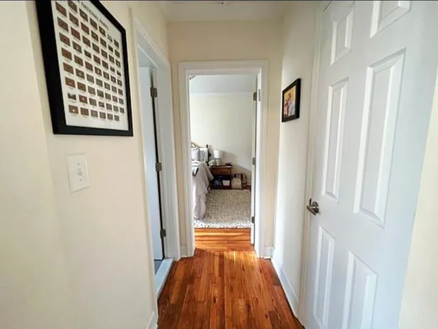 a view of a hallway and a livingroom with wooden floor