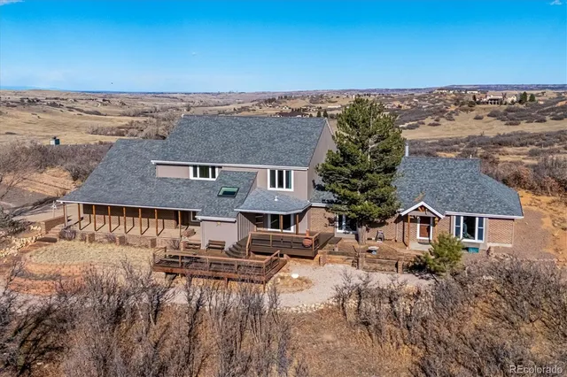 an aerial view of a house with a yard and mountain view