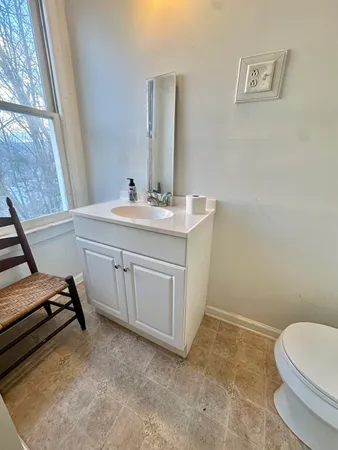 a bathroom with a sink a toilet and mirror