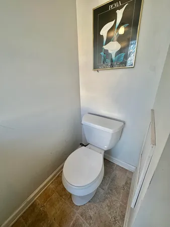 a white toilet sitting next to a white wall