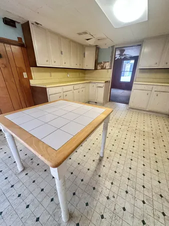 a kitchen with a sink a stove top oven and cabinetry