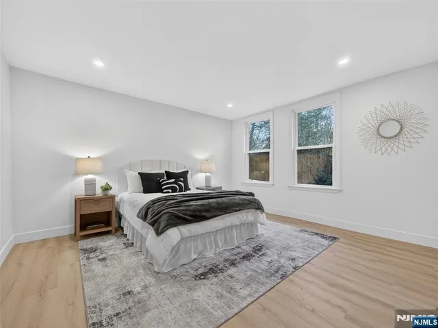 a bedroom with a bed and wooden floor