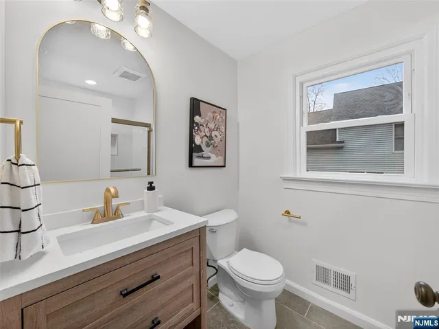 a bathroom with a toilet a sink and mirror