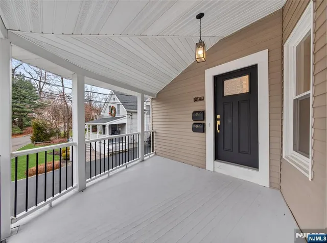 a view of a porch with wooden floor and iron stairs