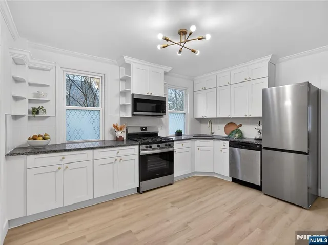 a kitchen with a refrigerator stove top oven and sink