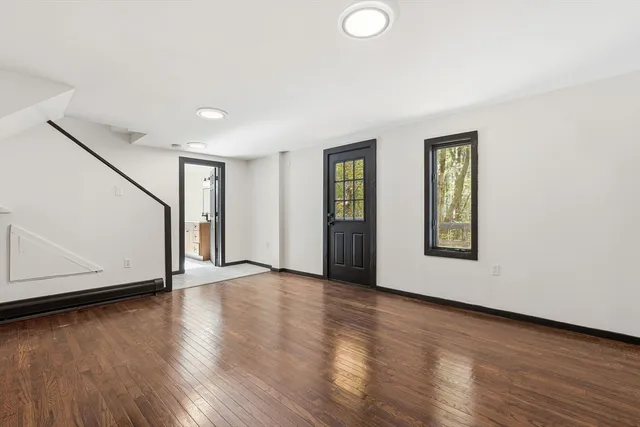 a view of an empty room with closet and a window