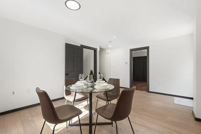 a kitchen with refrigerator a stove a sink dishwasher and white cabinets with wooden floor