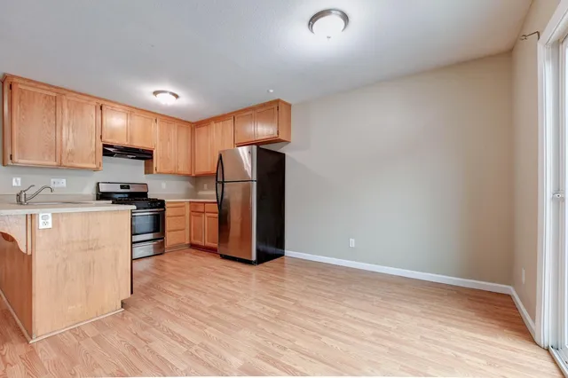 a kitchen with refrigerator cabinets and wooden floor