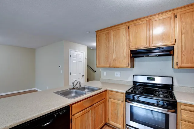 a kitchen with granite countertop a stove sink and cabinets