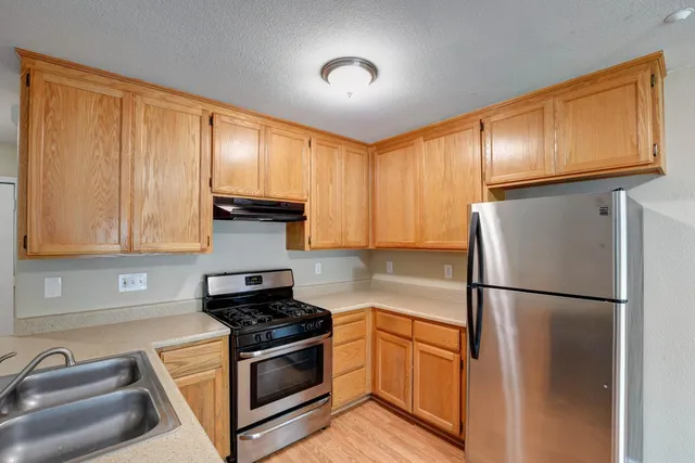 a kitchen with a refrigerator sink and cabinets
