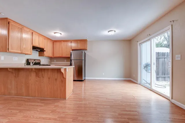 a kitchen with stainless steel appliances granite countertop a refrigerator a sink a stove a microwave and wooden cabinets