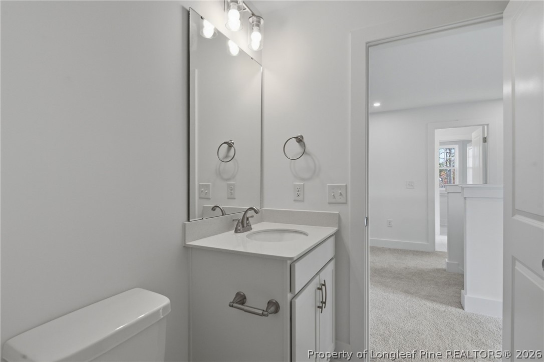 96 Graduate Ct Spring Lake Spring Lake, NC 28390 - Photo 25 of 49 a bathroom with a sink a toilet a mirror and vanity