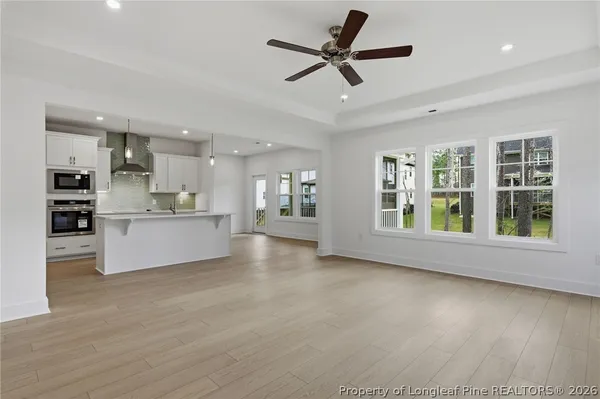 a kitchen with stainless steel appliances granite countertop white cabinets a microwave oven and white cabinets
