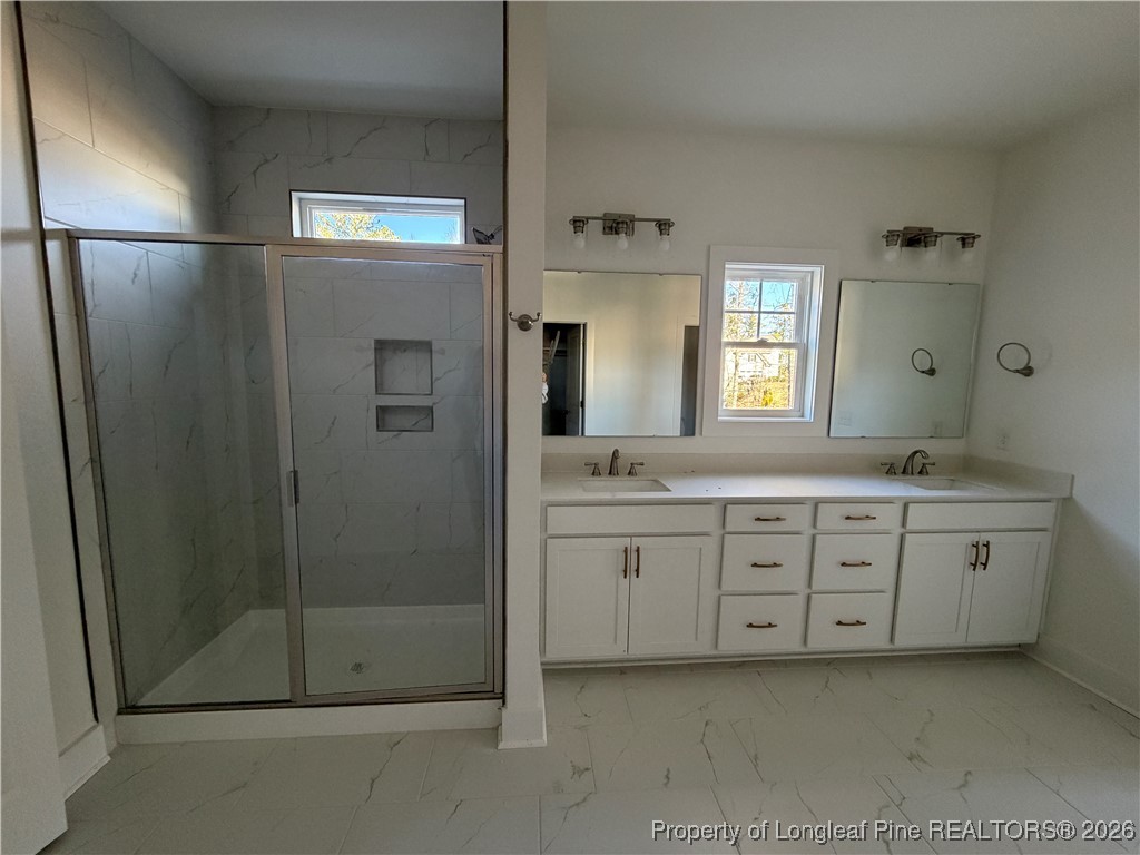 96 Graduate Ct Spring Lake Spring Lake, NC 28390 - Photo 7 of 33 a spacious bathroom with a shower a sink and a mirror