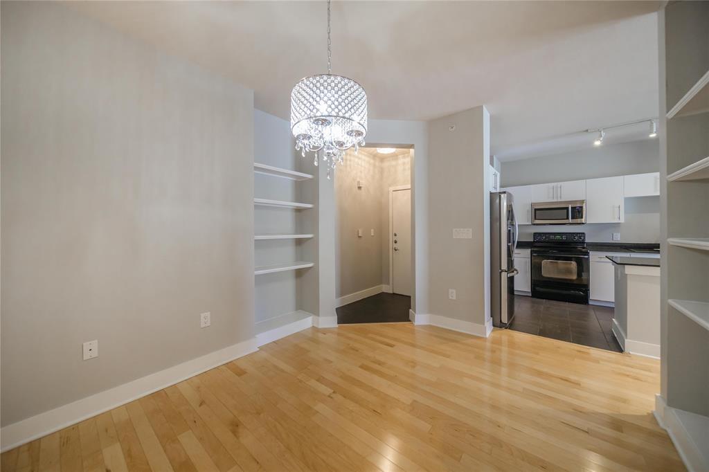 4414 Cedar Springs Road, Unit 214 Dallas, TX 75219 - Photo 4 of 29 Unfurnished dining area with a chandelier, dark wood-type flooring, built in features, and rail lighting