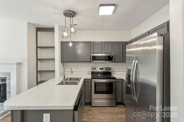 a kitchen with stainless steel appliances a refrigerator a stove a sink and a island