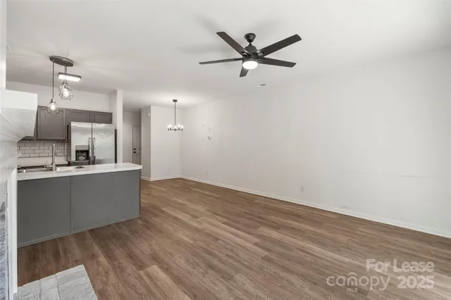 a view of a kitchen with wooden floor and a ceiling fan